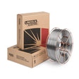 A 33 lb spool of Lincoln ED029204 Outershield 71 Elite 0.052 in Flux-Cored FCAW-G Welding Wire is displayed in front of two stacked Lincoln Electric boxes with the brand’s bold black and red design and logo.