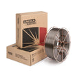A large spool of Lincore 55 welding wire with a metallic sheen is placed in front of two brown Lincoln Electric boxes featuring the company logo and a graphic design, ideal for abrasion resistant applications.