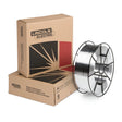 A spool of SuperGlaze 5356 MIG aluminum welding wire is positioned in front of two brown Lincoln Electric branded boxes, one upright and the other lying flat. The boxes feature a bold, stylized graphic with black and red accents.