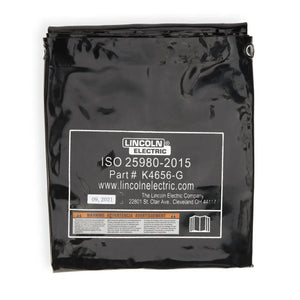 A folded dark green vinyl welding screen, Lincoln Flame Retardant Welding Curtain 6 x 8 ft (K4658-G), displays printed details, warning, and ISO 25980-2015 compliance—ensuring flame retardancy and enhanced welder safety.