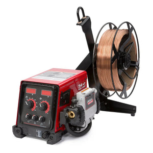 A red Lincoln Flex Feed 74 HT Digital U/I, Hvy. Dty. Reel K3883-12 sits beside a large copper welding wire spool on a black bracket, featuring control knobs, a digital interface, cables, and connectors for welding operations.