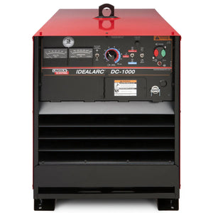 A front view of the Lincoln Idealarc DC-1000 Subarc Welder - K1386-3 shows its rectangular shape with a red top, black body, analog gauges, control knobs, warning labels, and bottom vent slats for cooling.