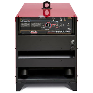 A front view of a red Lincoln Idealarc DC600 with VRD Multi-Process Welder (K1288-28) shows the control panel with knobs, switches, meters, and labels. The lower section is open, revealing an empty shelf and a coiled power cable.