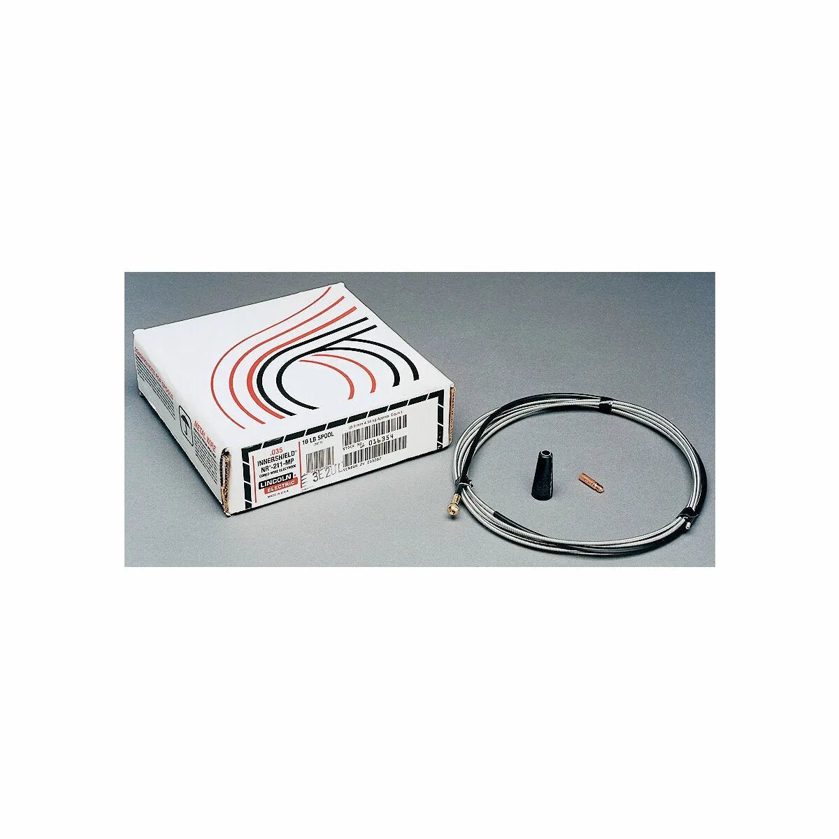 A coiled bicycle brake cable, a black cable cap, and a copper ferrule are beside the Lincoln Innershield Welding Kit .045 in (1.2 mm) K549-4 box, which features black and red curved lines, on a gray surface.