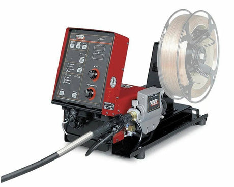 A red and black Lincoln LN-10 BENCH MODEL K1559-3 wire feeder, discontinued (see K5000-2), sits on a black base with control knobs, buttons, display panel, spool of welding wire, and a welding gun cable attached at the front.