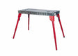 The Lincoln Portable Welding Table and Workbench K5334-1 features a rectangular metal top with holes and slots, sturdy adjustable red legs for enhanced stability, and a lightweight design perfect for any workshop.