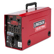 A red Lincoln Electric 25M Power Feed welding machine with a black handle on top, MAXTRAC drive system, control panel, display screens, and various switches and ports—ideal for push-pull welding applications.