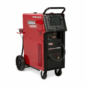 The Lincoln Power Wave 300C Standard - K4487-1 is a red multi-process welder with advanced waveform control, front panel display and knobs, top handle, wheels for mobility, and a black hose connected at the front.