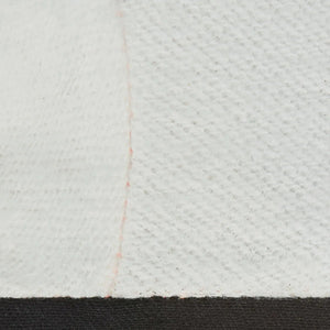 Close-up of white textured fabric with a subtle seam and faint pink stitch, echoing the quality in Lincoln Premium 7 Series Elkskin Stick/MIG Welding Gloves L K4787-L. The bottom edge meets a bold black strip for striking contrast.