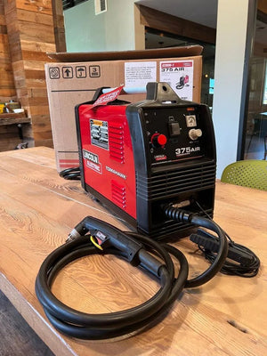 Lincoln Tomahawk 375 AIR Plasma Cutter (U2806-1) with cable and torch on table, WeldingMart welding equipment in background.