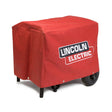 The Lincoln Tube Frame CanVAS Cover K2804-1 is a red, flame-retardant canvas cover with the Lincoln Electric logo in white and black. It fastens with metal snaps, fits over wheeled machines, and leaves only wheels and legs visible.