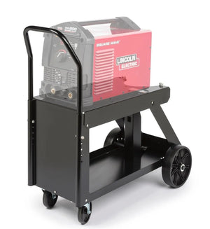 A black, metal welding cart with an adjustable handle, two large rear wheels, two small front casters, a lower shelf for welding accessories, and a red Lincoln Electric welding machine on top.